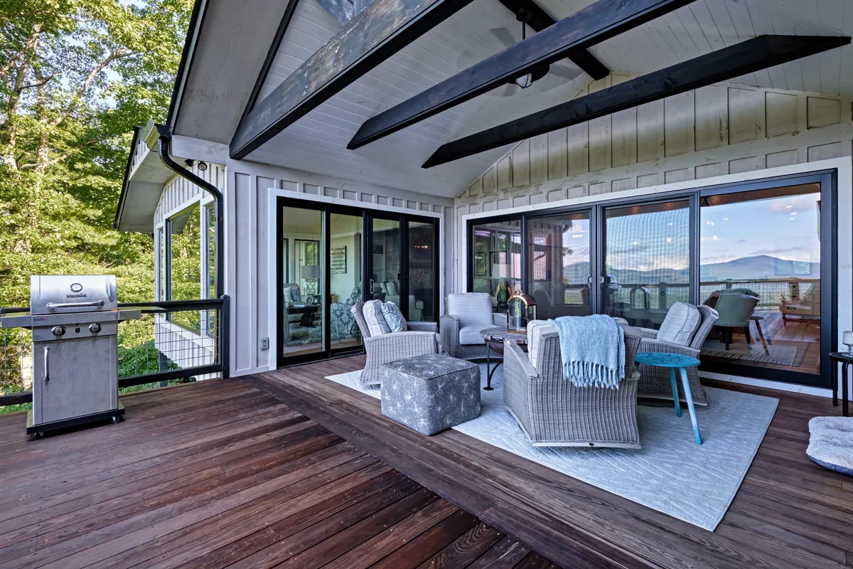 An outdoor seating area with a grill and uninterrupted mountain views, perfect for alfresco dining. The setup includes comfortable furnishings and invites guests to enjoy barbecuing or relaxing while taking in the scenery.